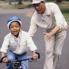 Man teaching young boy to ride a bike